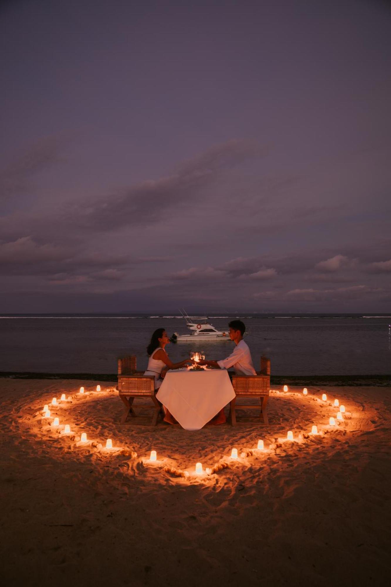 赛达拉精品海滩度假村 努沙杜瓦 外观 照片 A couple dining on a beach at night